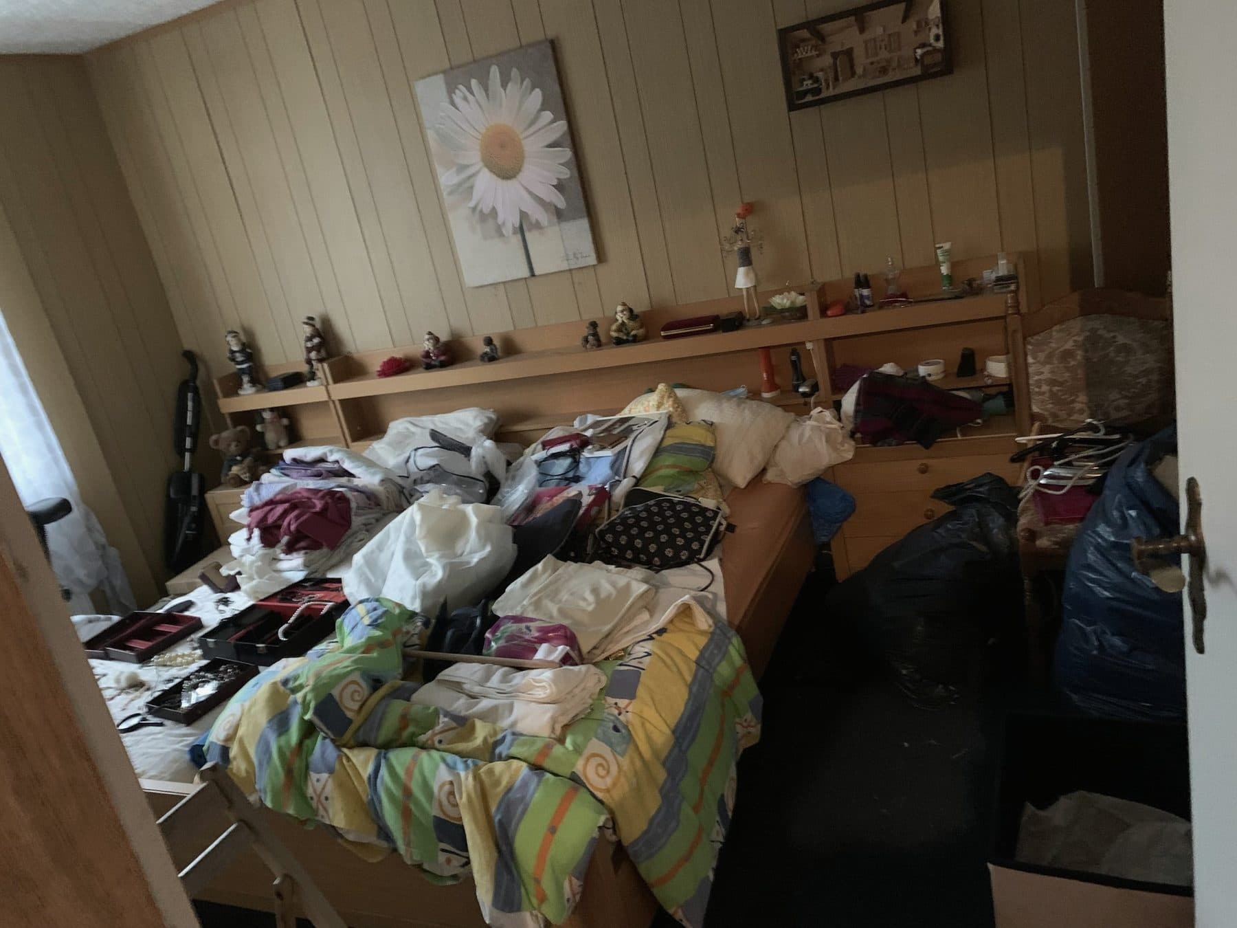 Schlafzimmer vor der Räumung mit Bett, Kleidung und Hausrat