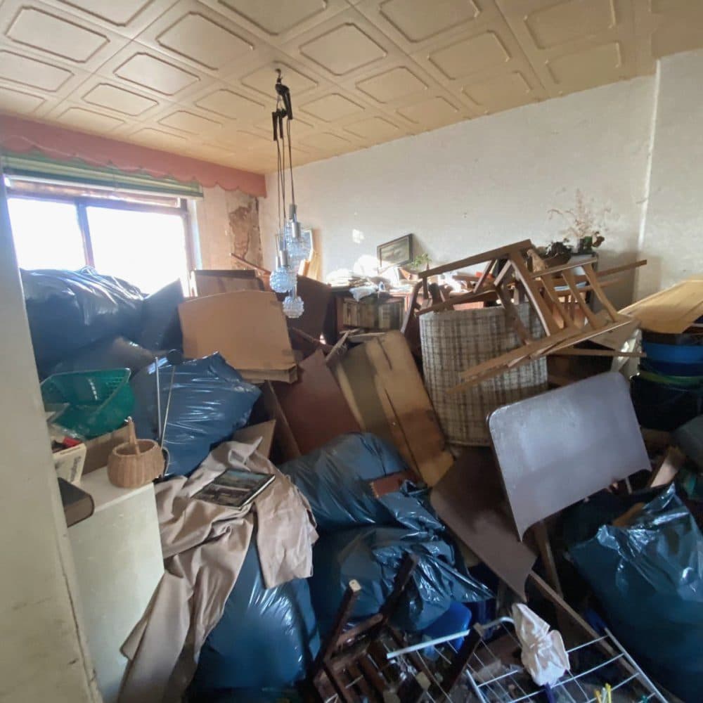 Zimmer voller Säcke, Stühle und Möbelteile vor der Räumung