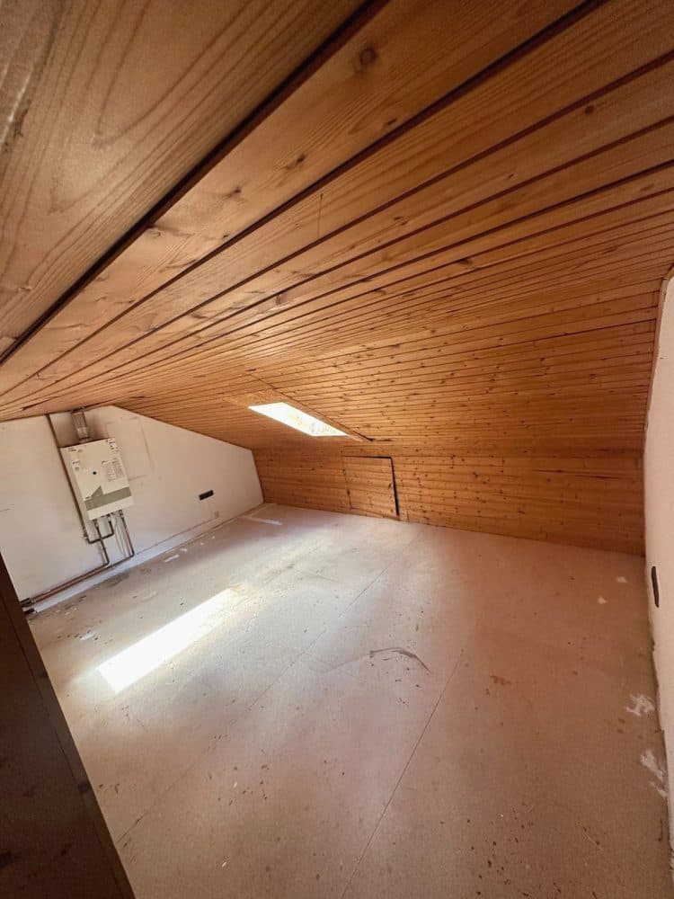 Leerer Dachboden mit Holzverkleidung und Dachfenster